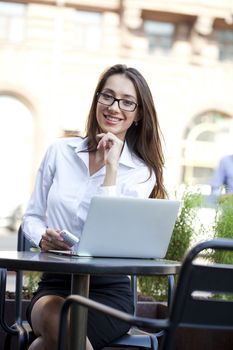 Portrait of young businesswoman working on a laptop