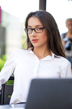 Portrait of young businesswoman working on a laptop