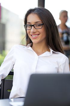 Portrait of young businesswoman working on a laptop