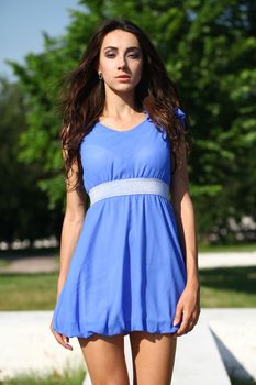 Sexy woman in a blue dress on the street