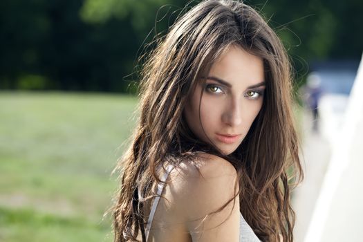 Portrait of a beautiful sexy young brunette woman in summer park