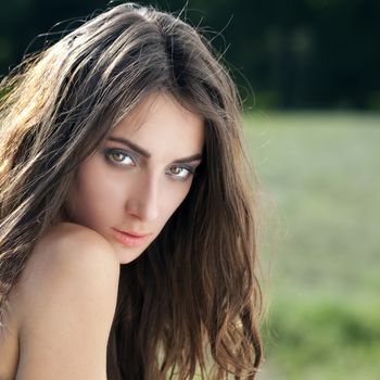 Portrait of a beautiful sexy young brunette woman in summer park