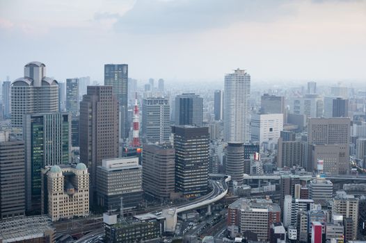 Osaka city skyline from the Umeda Sky Building on a misty day showing the modern architecture and skyscrapers in the CBD area with flyovers and infrastructure