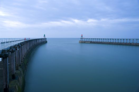 Entrance to the harbour at Whitby, North Yorkshire with its two breakwaters and navigation lights that are extensions to the original stone piers