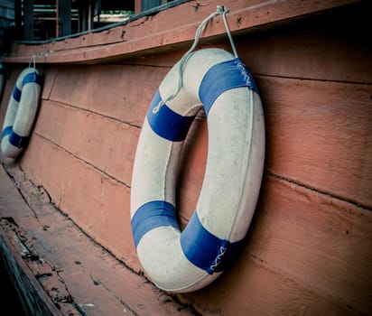lifebuoy blue stripes. attached to side of the ship. readily available.