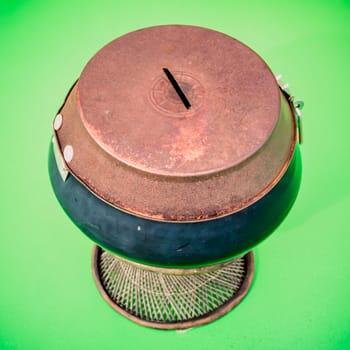old alms bowl on green background