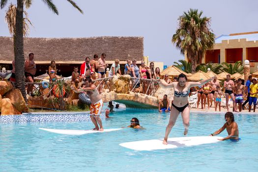 BORJ CEDRIA, TUNISIA - AUGUST 5: Tourists in animation competition program on holiday in an hotel Carribean World in pool August 5, 2014 Borj Cedria, Tunisia. 