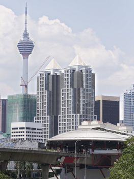 Kuala Lumpur skyline with a light rail station in the foreground and there Menara Kuala Lumpur Tower in the background.