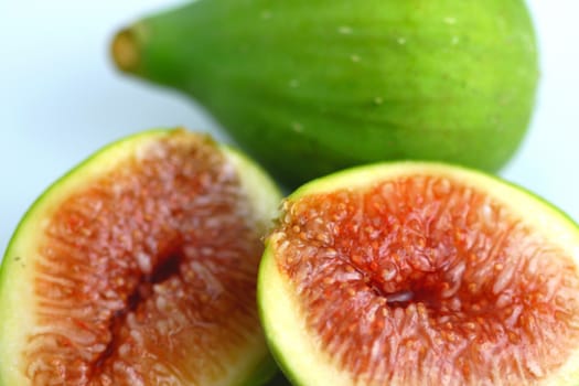 Green fig cut open on white background.