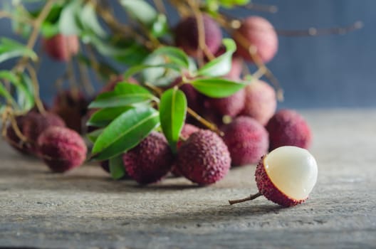 Lychee with leaves on a wooden table