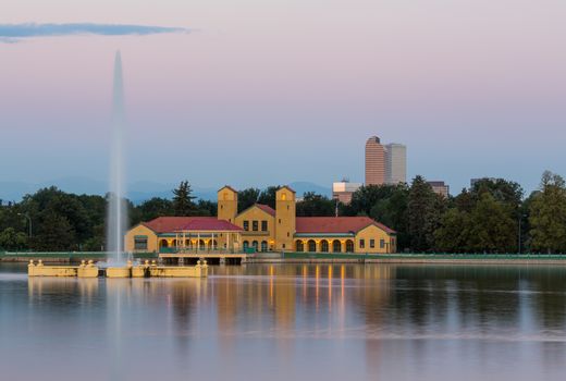 Fountain and Boathouse at Ferril Lake with the city skyline of Denver Colorado in background just before sunrise
