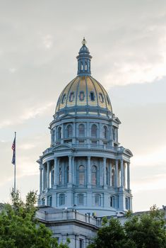 The gold leaf covered dome of the State Capitol Dome in Denver Colorado shortly after sunrise