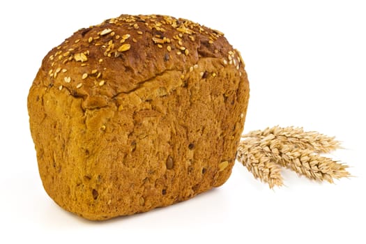 A loaf of bread with sunflower seeds, sesame seeds, grains of wheat and spikelets of wheat on a white background