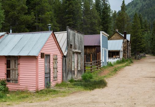 Old wooden houses line the main street of ghost town of St Elmo in Colorado