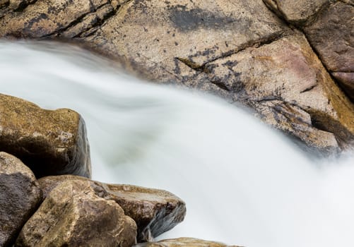 Water cascading between granite rocks in simple blurred motion images of waterfall