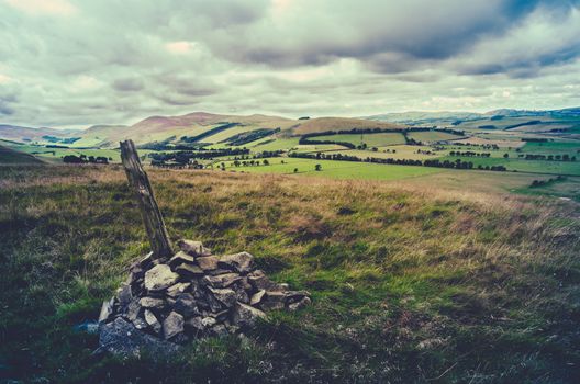 Retro Filtered Style Photo Of A Cairn On The Top Of A Hill In Scottish Landscape