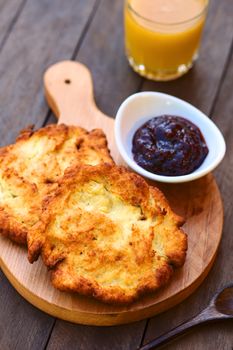 Freshly prepared traditional Hungarian deep fried flat bread called Langos made of a yeast dough, which is usually eaten with garlic, grated cheese and/or sour cream, or sweet with jam (Selective Focus, Focus in the middle of the langos) 

 