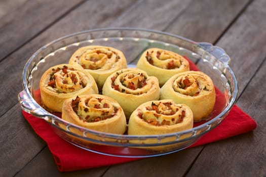 Freshly baked homemade rolls filled with tomato, ham and herbs on glass plate (Selective Focus, Focus on the front of the rolls in the middle row) 