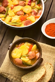 Hungarian dish called Paprikas Krumpli (Potato with Paprika), a stew made of potato, onion, pepper, tomato and sausage, seasoned with the Hungarian paprika and salt (Selective Focus, Focus in the middle of the dish in the bowl) 