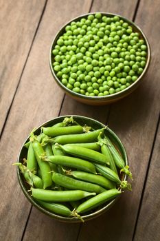 Peapods (lat. Pisum sativum) and peas in bowls (Selective Focus, Focus into the middle of the peapods)