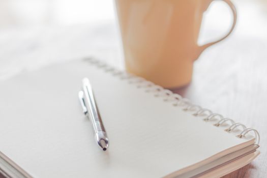 Notebook with pen on wooden table, stock photo