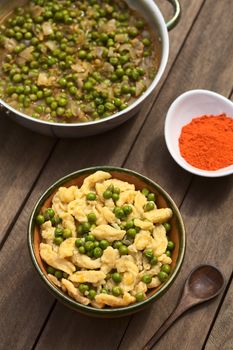 Hungarian vegetarian pea stew seasoned with paprika served with homemade noodles called Nokedli or Galuska in rustic bowl (Selective Focus, Focus on the middle and the lower part of the dish)