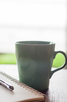 Green mug in coffee shop, stock photo