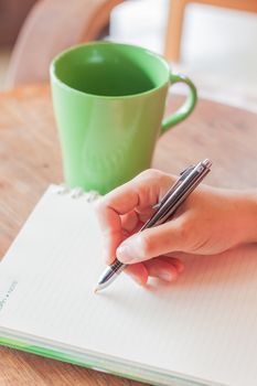 Writing important note in coffee shop, stock photo