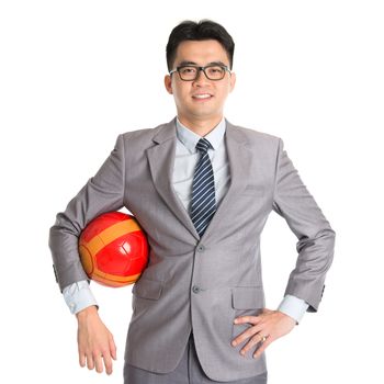 Portrait of Asian businessman with soccer ball standing isolated on white background.