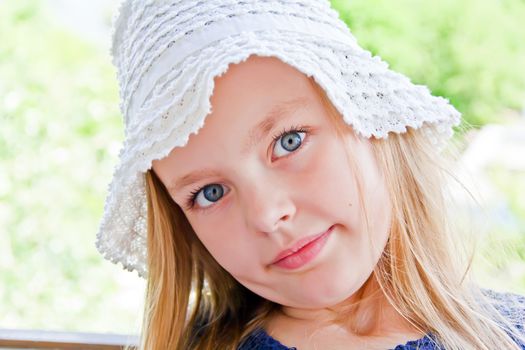 Cute girl with big blue eyes in white hat