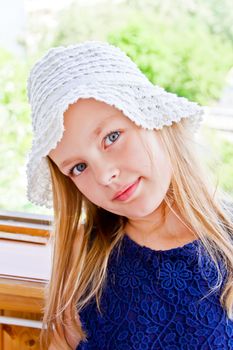 Cute girl with big blue eyes in white hat