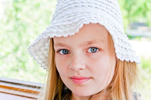 Cute girl with big blue eyes in white hat