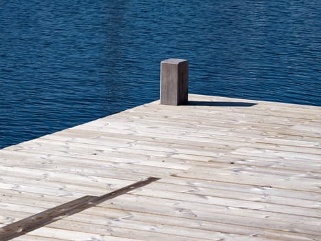 Small beautiful seaside wooden jetty dock pier deck by the ocean 
