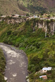 The Pastaza River and the small town of Banos in Ecuador on the cliffs with some waterfalls dropping down 