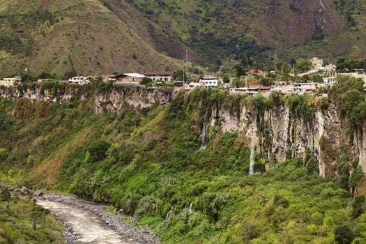 The Pastaza River and the small town of Banos in Ecuador on the cliffs with some waterfalls dropping down 