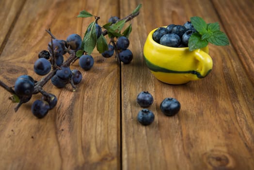 Fresh blueberries on kitchen wooden table with yellow pot