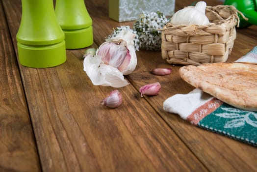 Fresh garlic bulb and naan bread on kitchen table