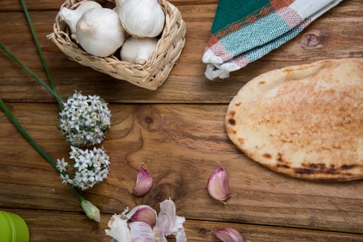Fresh garlic bulb and naan bread on kitchen table