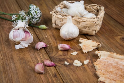 Fresh garlic bulb and flowers and naan bread on kitchen table