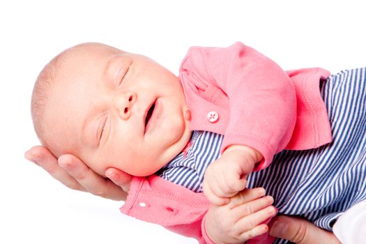 Happy cute baby girl laying in hand asleep with eyes clossed, on white.