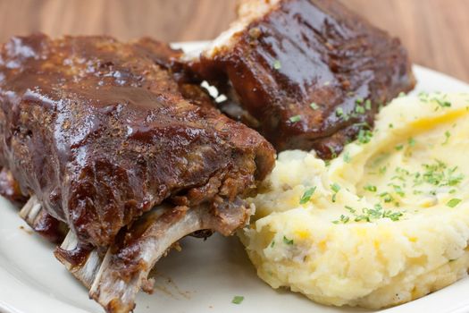 Baby back ribs and cheddar garlic mashed potatoes with green chives on top.