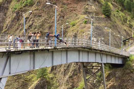 BANOS, ECUADOR - FEBRUARY 26, 2014: Unidentified person jumping down the San Francisco Bridge on February 26, 2014 in Banos, Ecuador. Banos is popular for its outdoor activities such as bridge jumping. The jump from this bridge is 45 meters into the canyon of the Pastaza River. 