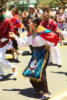 BANOS, ECUADOR - MARCH 2, 2014: Unidentified people dressed in traditional clothes and dancing to music on the carnival parade on Maldonado street on March 2, 2014 in Banos, Ecuador.