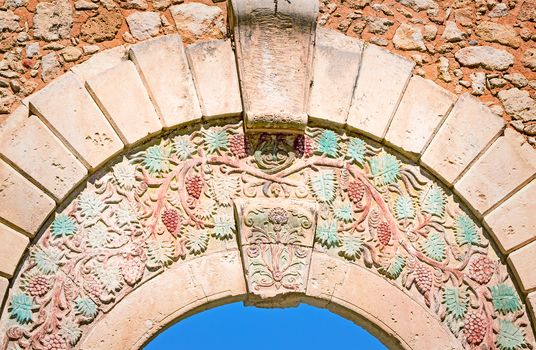 Fragment of the ancient gate decorated with the image of grapes, separating old part of the city of Retimno from the modern. Island of Crete, Greece.