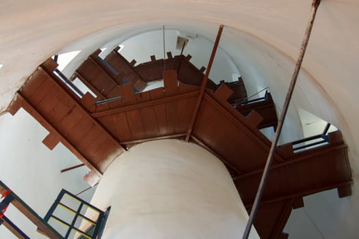 Brown planks inside a white lighthouse stairway