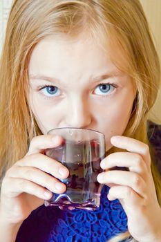 Cute girl with blond long hair drinking beverage
