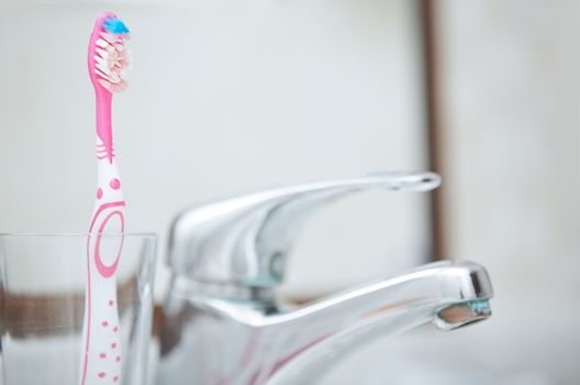 Toothbrush and water tap in domestic bathroom