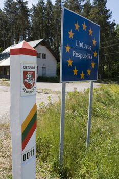 Lithuania country border sign between Latvia and Lithuania with coat of arms and flag.