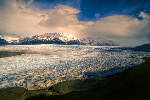 Sun setting down over sunlit mountains in Torres del Paine National Park                     