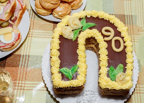 homemade birthday cake for ninety anniversary with other snacks on desk